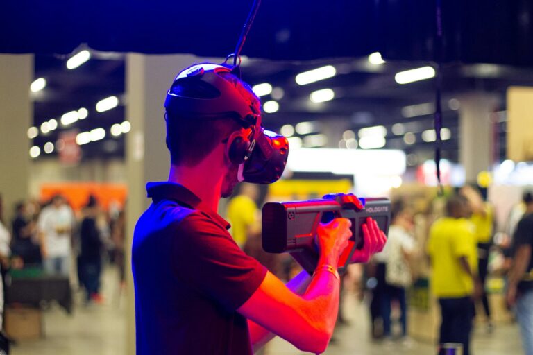 Back view of young male in casual clothes and VR headset standing in spacious hall while testing device operation